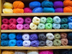 Image of shelves laden with colourful knitting yarns